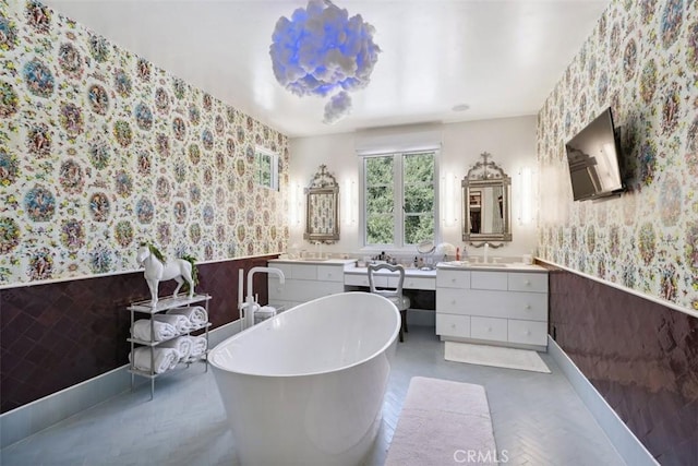 bathroom featuring a tub to relax in, vanity, and tile walls