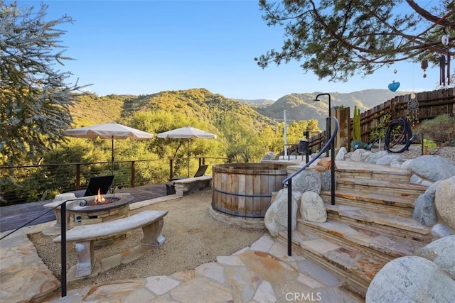 view of patio with a mountain view and a fire pit