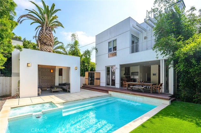 back of property featuring a pool with connected hot tub, a patio, an outdoor living space, and stucco siding