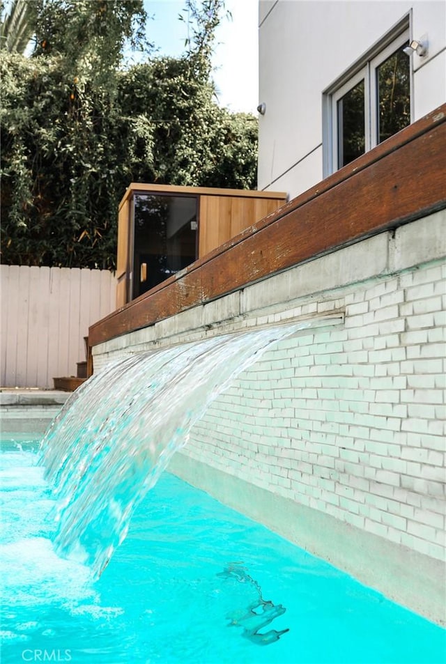 view of swimming pool featuring fence