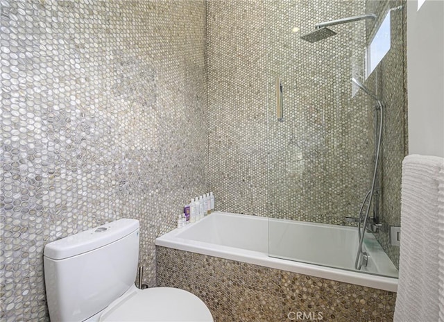 full bath featuring toilet and tiled shower / bath