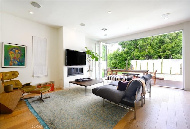 living room with light wood-style floors, recessed lighting, and visible vents