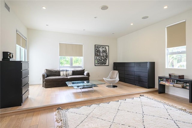 living area featuring recessed lighting, visible vents, baseboards, and wood finished floors