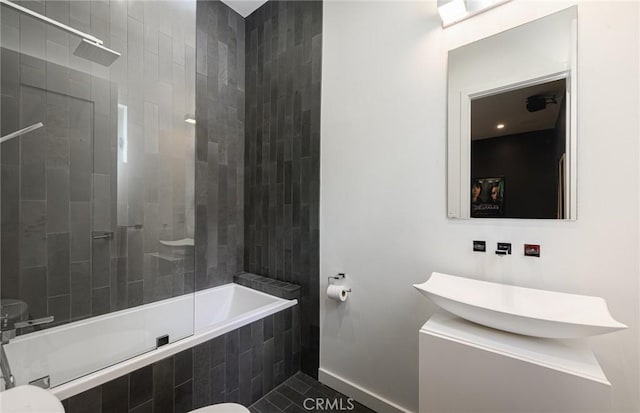 full bathroom featuring tiled shower / bath combo, a sink, and baseboards