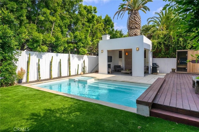 view of swimming pool featuring a fenced backyard, a yard, a deck, and area for grilling