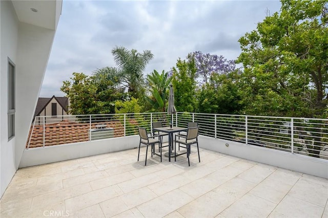 view of patio with a balcony and outdoor dining area