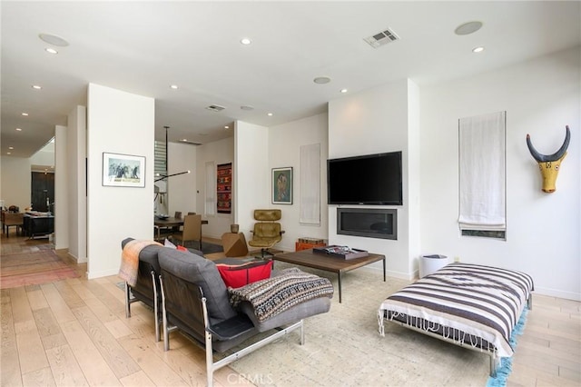 living room with recessed lighting, baseboards, visible vents, and light wood finished floors