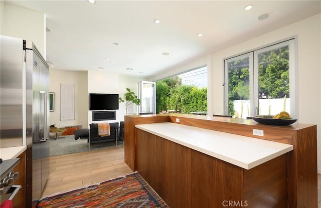 kitchen with light countertops, high quality fridge, and light wood-style floors