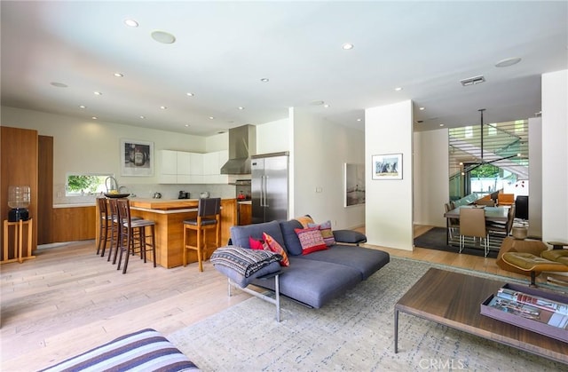 living room featuring recessed lighting, visible vents, and light wood finished floors