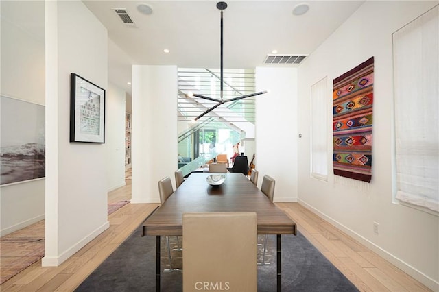 dining space featuring light wood finished floors, baseboards, and visible vents