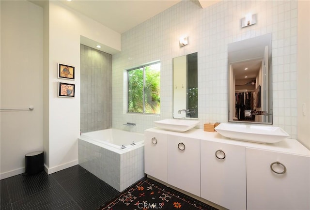 full bathroom with a garden tub, tile walls, a sink, and tile patterned floors