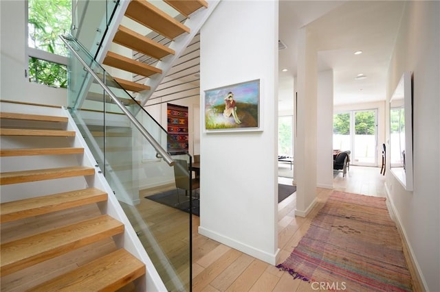 staircase with hardwood / wood-style floors, recessed lighting, and baseboards