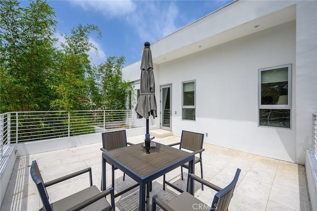 view of patio / terrace with a balcony and outdoor dining area