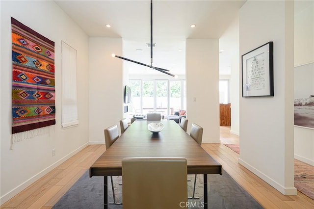 dining space featuring light wood-type flooring, visible vents, and baseboards