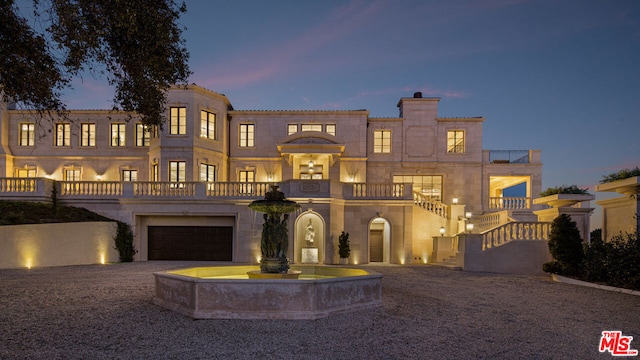 mediterranean / spanish-style home featuring a garage and a balcony