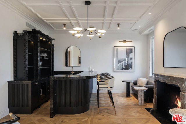 dining room featuring a fireplace, a chandelier, indoor wet bar, and light parquet floors