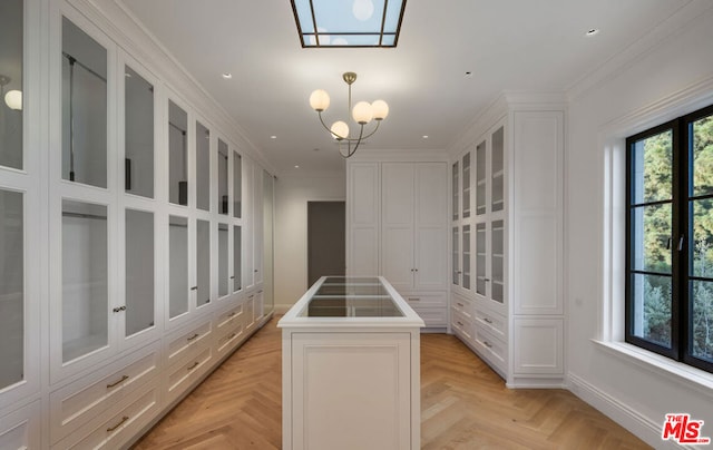 walk in closet featuring an inviting chandelier and light parquet floors