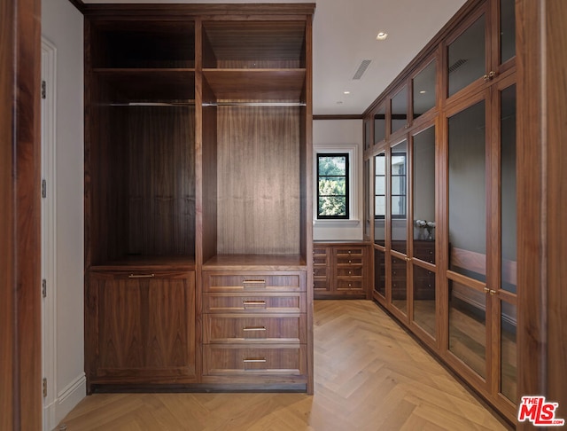 walk in closet with french doors and light parquet floors