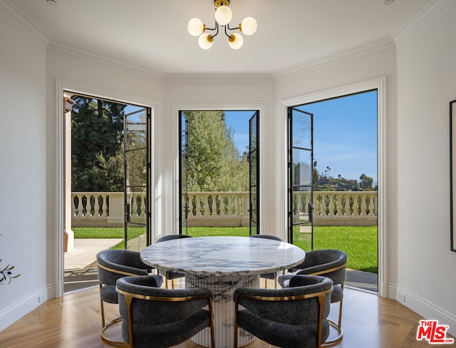 dining room with a notable chandelier, ornamental molding, and light parquet floors