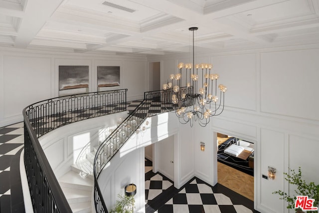 stairway featuring coffered ceiling, beam ceiling, crown molding, and a chandelier