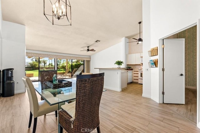 dining area featuring vaulted ceiling, ceiling fan with notable chandelier, and light hardwood / wood-style flooring