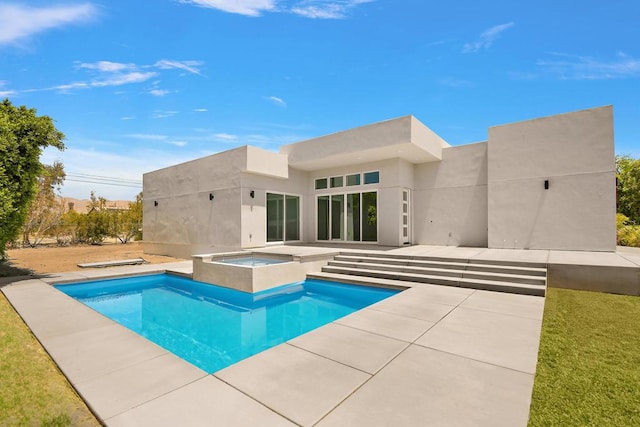 rear view of property featuring a patio and a pool with hot tub