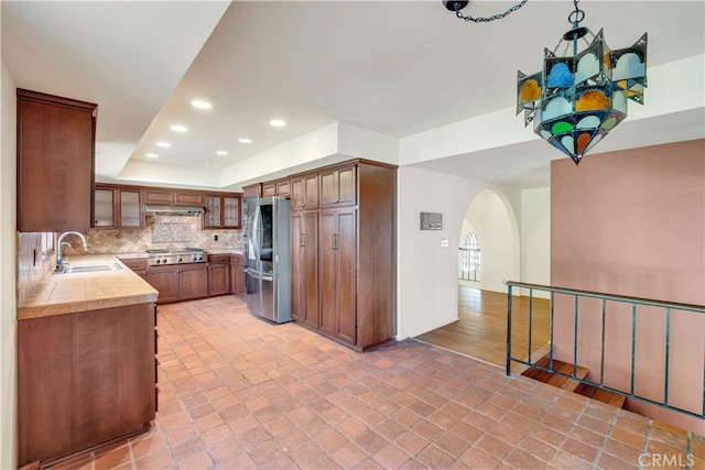 kitchen with tasteful backsplash, sink, and appliances with stainless steel finishes