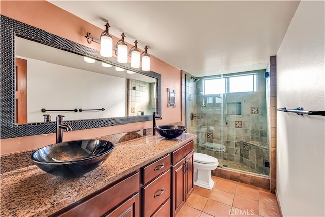 bathroom with tile patterned flooring, vanity, toilet, and an enclosed shower