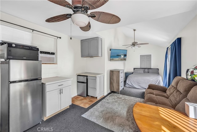 bedroom featuring stainless steel fridge, ceiling fan, refrigerator, light tile patterned flooring, and vaulted ceiling