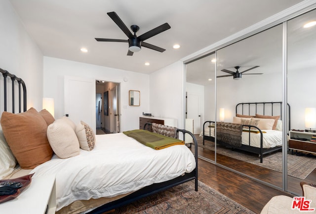 bedroom with ceiling fan, dark hardwood / wood-style floors, and a closet