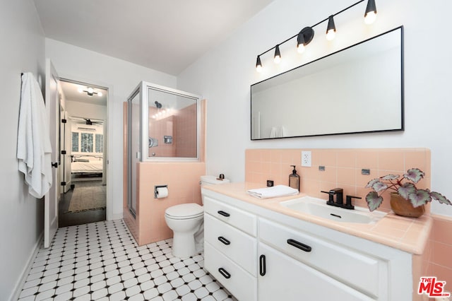 bathroom featuring walk in shower, vanity, tile walls, tile patterned flooring, and toilet