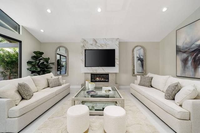 living room with a premium fireplace and vaulted ceiling