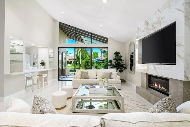 living room featuring a premium fireplace and high vaulted ceiling