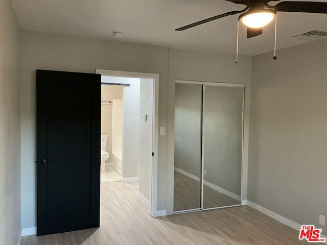 unfurnished bedroom featuring ceiling fan, a closet, and light wood-type flooring