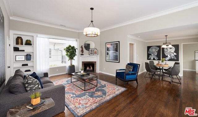 living room with crown molding, a notable chandelier, and wood-type flooring