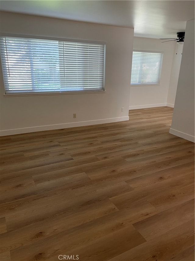 empty room with ceiling fan and dark hardwood / wood-style flooring