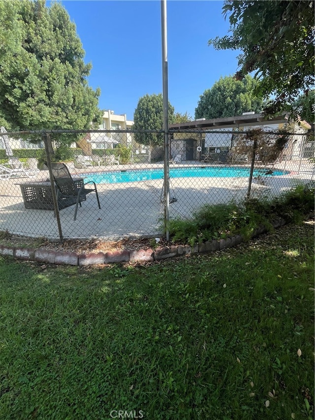 view of pool with a yard