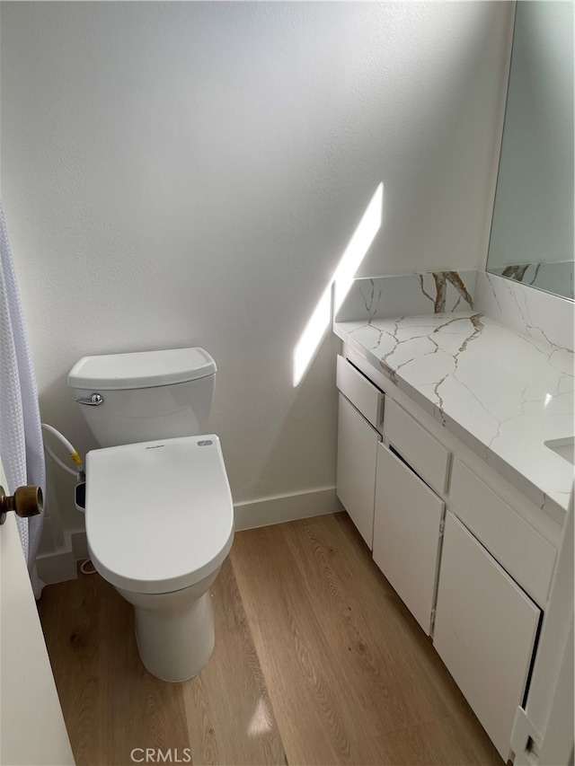 bathroom with vanity, hardwood / wood-style floors, and toilet