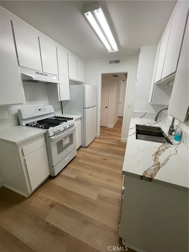 kitchen featuring white appliances, light hardwood / wood-style floors, sink, and white cabinets