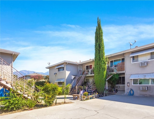 view of front of home with a mountain view and a wall mounted AC