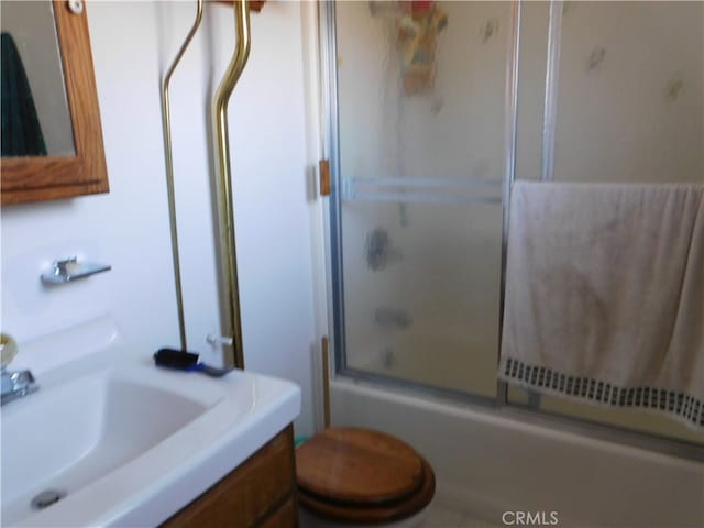 full bathroom with vanity, enclosed tub / shower combo, and toilet