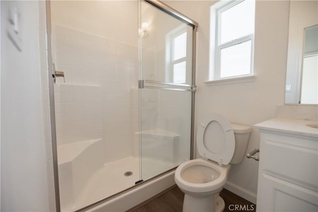 bathroom featuring hardwood / wood-style flooring, vanity, toilet, and a shower with door