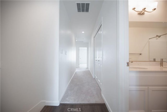 hallway featuring sink and hardwood / wood-style flooring