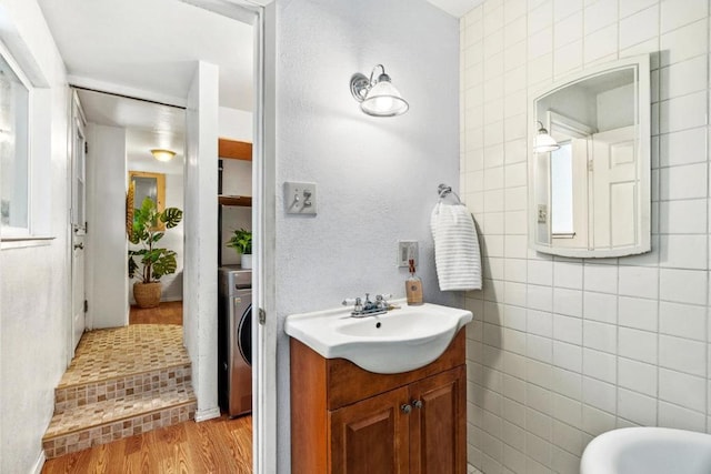 bathroom with wood-type flooring, washer / dryer, and vanity