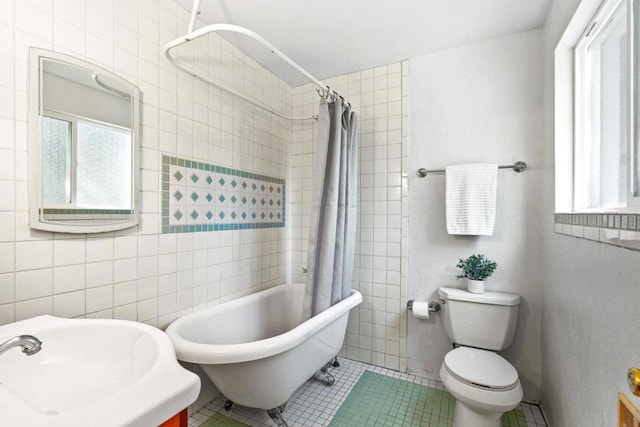 full bathroom with toilet, sink, tile patterned flooring, and tile walls