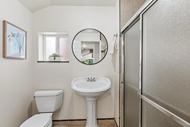 bathroom featuring lofted ceiling, toilet, an enclosed shower, sink, and tile patterned flooring