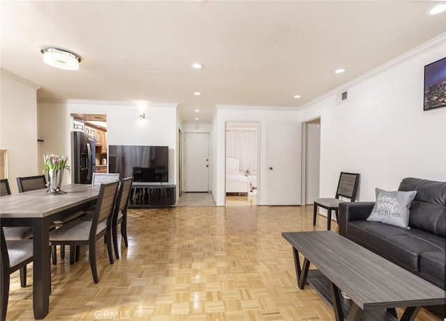 dining space with crown molding and light parquet flooring