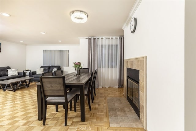 dining area with a fireplace, light parquet flooring, and crown molding