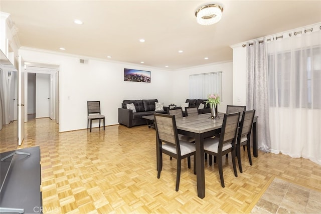 dining room with light parquet floors and crown molding