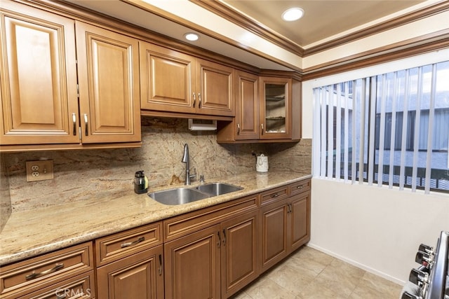 kitchen with sink, tasteful backsplash, light tile patterned floors, light stone countertops, and ornamental molding